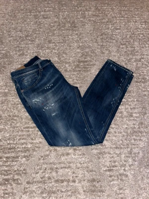 Dondup George  - Hej jag säljer ett par Dondup George jeans i riktigt snygg marinblå färg med väldigt unika slitningar perfekt för dig som vill ha ett par kvalitetsjeans med grym passform. Nypris ≈ 3000kr, mitt pris 899kr.  Skick: 9/10 Storlek: W34 Midja: 40cm Lår: 25cm Ytterlängd: 104cm Innerlängd: 80cm  Skriv gärna om du vill ha fler bilder eller har frågor!