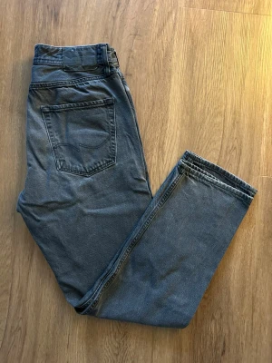 Svarta jeans från Jack & Jones 30/30 - Snygga svarta jeans från Jack & Jones i klassisk rak modell. Jeansen har fem fickor, knappgylf och är tillverkade i bomull med en skön jeanskänsla. Perfekta för dig som gillar en enkel och stilren look.