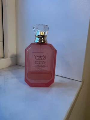 Kayali Eden Sparkling Lychee 39 - Trendig parfym med noter av svartvinbär, sparkling lychee, ros Damascena, sockrad viol och bärnsten. Perfekt för dig som vill sticka ut med en modern och fräsch doft. Har förvarats mörkt och svalt. Återstående mängd se bild men uppskattar den till 12-15 ml 