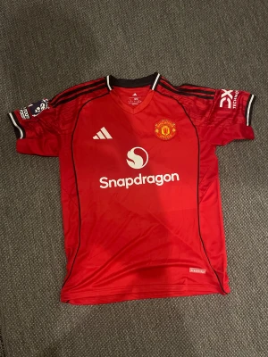 Manchester United Mainoo matchtröja 25/26 - Säljer den officiella nya Manchester United matchtröja 25/26  i storlek L, med Mainoo på ryggen. Nytt skick 