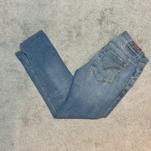 Blå jeans från Dondup, stl 31 - Snygga blå jeans från Dondup i modellen George Skinny Fit. Jeansen har klassisk femficksdesign, ljus tvätt med lätt slitning och smal passform. Materialet är mjukt jeans med stretch för extra komfort. Måtten på jeansen går att söka upp, hör av er vid frågor!