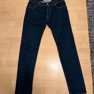 Jacob Cohën Nick 10/10 skick stl.35 - Mörkblå jeans från Jacob Cohën, modell Nick. 10/10 skick, använda några få gånger, säljs då stl. 34 passar mig bättre. Parfymen sitter kvar, vilket tyder på begränsad användning. Slim fit passform. Nypris: ca 5499:-