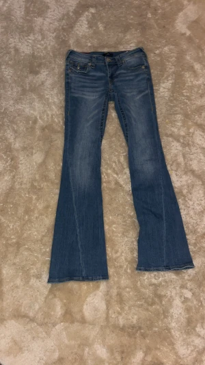 True Religion Joey Low-Rise Flare Jeans - Jag säljer ett par jätte snygga jeans från true religion, storlek w23. Jag har endast testat dem , men aldrig använt dem så i bra nyskick. Priset ligger på 1149 kr, kan diskutera priser💞jag är 1,52 cm lång och är för stora för mig.
