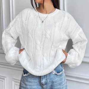 Vit kabelstickad tröja - Storlek L liten i storlek. Säljer en vit kabelstickad tröja med rund hals och långa ärmar. Tröjan har en chunky känsla och breda muddar vid ärmslut och nederkant. Perfekt för lager-på-lager och ger en clean, fräsch look till jeans eller kjol. 