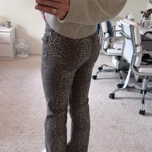 Nelly leopardmönstrade bootcut jeans  - Säljer ett par snygga lågmidjade jeans med leopardmönster i mörkbruna och beige toner från Nelly. Dom passar olika storlekar beroende på hur man gillar passformen🤎