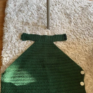 Mörkgrön stickad topp med pärlknappar - Virkad halter-neck topp med tre knappar vid vänster sida samt nacke