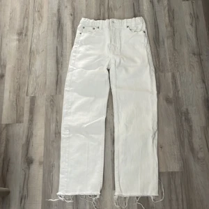 Vita raka jeans - Vita jeans från 157 med raka ben och snygga råa kanter nertill. Klassisk femficksmodell med silverfärgade nitar och bälteshällor. Jeansen har hög midja och är tillverkade i bomullstyg med en mjuk känsla.