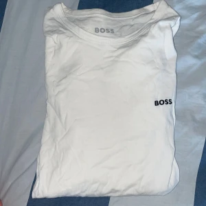 långärmad tröja BOSS - Vit långärmad tröja från BOSS i mjuk bomull. Klassisk passform med rund halsringning och diskret BOSS-logga broderad på bröstet. Perfekt basic att ha i garderoben för en clean och stilren look.