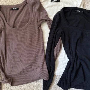 Ribbade långärmade toppar Bik Bok XS - Tre ribbade långärmade toppar från Bik Bok i storlek XS. En i svart, en i vit och en i en ljusbrun/lila nyans. Alla har rundad, något djupare urringning och är figurnära i modellen. Den svarta har ett litet hål på axeln, vilket sista bilden visar💗