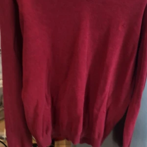 Vinröd långärmad tröja - En enkel vinröd långärmad tröja med rund halsringning. Tröjan har en klassisk passform och är perfekt för lager-på-lager under höst och vinter. Materialet känns mjukt och bekvämt mot huden.