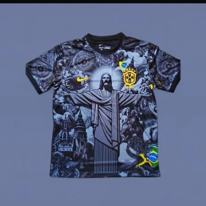 Brasil Nike svart fotbollströja - Unik svart Brasilien fotbollströja från Nike med detaljerat tryck av Kristusstatyn och brasilianska symboler. Tröjan har korta ärmar, rund hals och broderade loggor i gult. Materialet är lätt och andas, perfekt för match eller streetstyle.