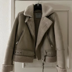 Beige teddyjacka från Stradivarius XS - Snygg beige teddyjacka från Stradivarius med bred krage och detaljer i fuskpäls.  Perfekt för kalla dagar. Använt knappt.