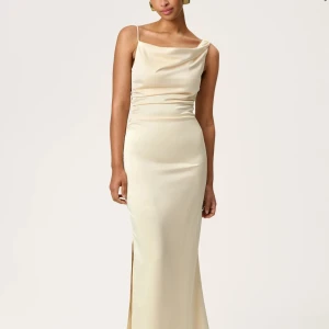 Champagnefärgad långklänning från Adoore - Supersnygg långklänning i champagnefärgad satin från Adoore. Klänningen har smala axelband, draperad halsringning och en slits på sidan. Sitter figurnära och ger en elegant siluett. Perfekt för dig som vill sticka ut med en stilren look.