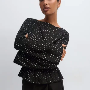 Svart prickig blus med volang - Populär prickig topp från Gina, helt slutsåld . Använt 1 gång. Skriv för fler bilder🩷