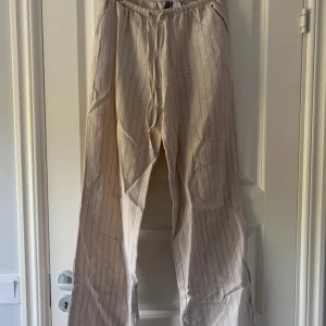 Beige randiga linnebyxor från H&M XS - Väldigt populär och många är intresserade. Säljs snabbt, så skynda att köpa. Först till kvarn!  Sitter jätte fint på och har fickor på sidorna av byxorna. Formar rumpan fint.