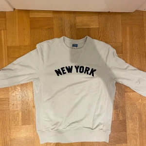 Ljusgrå sweatshirt från J.Crew - Snygg ljusgrå sweatshirt från J.Crew med svart 'NEW YORK'-text framtill.🙌👊