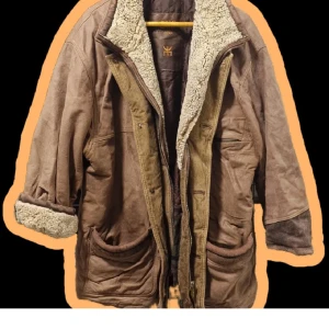 Skinjacka - Skinjacka från Saki i bra skick. Fårskin/ull i muddarna och quiltad insida. Har varit den perfekta oversized (uppskattar den till XL/XXL) vinterjackan i 2 år och nu får den vandra vidare då jag köpt en ny 🧡 väldigt härligt höstigt-over sized och har haft 2 tjocka tröjor under när jag var I Umeå förra vintern 🥰 en kan både ha ärmarna nedrullade eller upprullade (se bild)