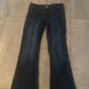 Mörkblå bootcut jeans från Gina Tricot - Snygga mörkblå jeans från Gina Tricot i storlek 152.  Säljs inte längre! Modellen har bootcut-ben och klassisk femficksdesign med dubbla knappar i midjan. Perfekta för dig som gillar en tidlös jeanslook med lite utsvängda ben. Använt 2 gånger!!