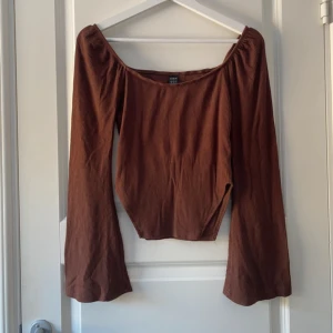 Brun ribbad topp med utsvängda ärmar - Superfin tröja i en smickrande brun nyans med en fyrkantig urringning som även kan bäras off-shoulder. De vida ärmarna ger en elegant touch, och de två slitsarna vid sidan av magen framhäver kroppen på ett snyggt sätt och får midjan att se mindre ut. Tillverkad i ribbigt material som sitter bekvämt och formar sig fint efter kroppen. Använd 2-3 gånger och i mycket bra skick! Säljer då den inte kommer till användning.  Vänligen läs min bio innan du gör ett köp