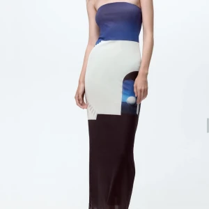 Tubklänning med grafiskt mönster från zara - Snygg lång tubklänning med grafiskt mönster i blått, vitt och svart. Klänningen är axelbandslös och har en figurnära passform som framhäver siluetten. Perfekt för dig som vill sticka ut med en modern och stilren look.