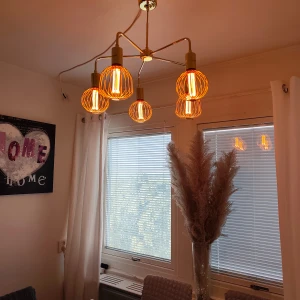 Modern taklampa med fem glödlampor i mässing - Stilren taklampa i mässing med fem ljuskällor och dekorativa burformade lampskärmar. Ger ett varmt och inbjudande sken, perfekt för matrum eller vardagsrum. Lampan är i mycket gott skick utan synliga defekter eller slitage.
