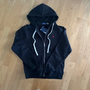Svart Ralph lauren kofta i storlek S - Säljer denna svarta ralph lauren kofta i storlek S-M. Det står L på insidan men den passar mest dels S. Väldigt skönt material på insidan! Säljer även en likadan i mörkblå så kolla profilen!