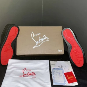 Christian Louboutin svarta sneakers mocka - Snygga svarta sneakers från Christian Louboutin i mocka med klassisk röd sula och broderad logga på hälen.akopi. Skorna är storlek 44