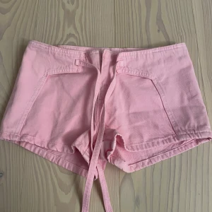Rosa shorts  - Snygga rosa shorts från Mango i storlek 38. Helt nya, oanvända med lappen kvar. Sitter lågmidjat och har snörning framtill.