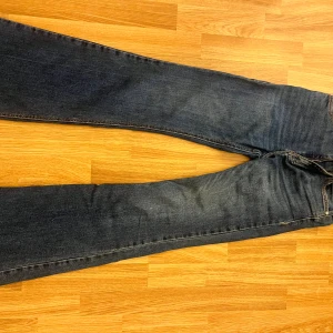 Blå bootcut jeans från Pull&Bear - Snygga blå jeans från Pull&Bear med klassisk bootcut-modell. Jeansen har fem fickor, dragkedja och knapp framtill samt kontrastsömmar. Perfekt för dig som gillar en tidlös och avslappnad look.