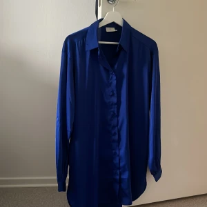 Blå satinliknande skjorta Gina Tricot - Blå längre skjorta från Kaffe i satin,knappt använd