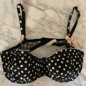 Polkadot bh 💕 - Jättesöt oanvänd polkadot bh från La Senza med vita prickar och söta ljusrosa rosetter på axelbanden. Axelbanden är justerbara och har samma prickiga mönster. Modellen är feminin och har fina volangdetaljer längs kanten. Säljs för den inte passar mig!!