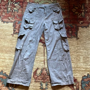 Coola grågröna cargobyxor  - Säljer ett par cargobyxor med flera fickor som jag köpte från emmiol. De är lite mer grönaktiga i verkligheten. Säljer eftersom de inte kommer till användning längre. Midjemåttet är 40cm tvärs över och innerbenslängd är 74cm. Storleken säger L men funkar även som M.