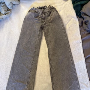 Grå wide jeans från Wera, stl 152 - Gråa jeans från Wera i modell wide med rak och bred passform. Byxorna har klassisk femficksdesign, resår i midjan och är tillverkade i ett mjukt denimtyg. Perfekta för dig som gillar en avslappnad och trendig look.