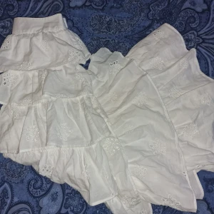 Vit volangkjol - Superfin vit maxikjol med flera lager volanger och broderade blommor. Söt och luftig med romantiska detaljer. Passar mig som har S så även liten S funkar. 