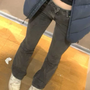 Svarta jeans från Gina Tricot - Svarta jeans från Gina Tricot med klassisk femficksdesign och silverfärgade detaljer vid knappar och nitar. Jeansen har rak passform och dragkedja i gylfen. Snygga att matcha med sneakers eller boots för en cool look.