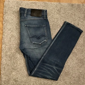 Replay jeans  - Snygga blå jeans från Replay med klassisk femficksdesign och raka ben. Mörkblå tvätt med ljusare partier och tydliga sömmar. Perfekta för en avslappnad och trendig look. Stl 30/30
