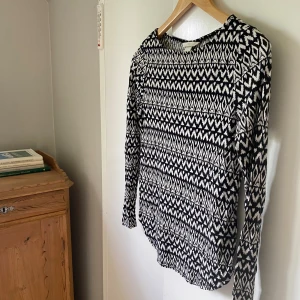 Svartvit mönstrad tröja  - Svartvit långärmad tröja från H&M i storlek XS. Tröjan har ett grafiskt mönster med zigzag och diamantformer, rund halsringning och är tillverkad i mjuk bomullsmix. Perfekt för dig som gillar stilrena men ändå iögonfallande plagg.