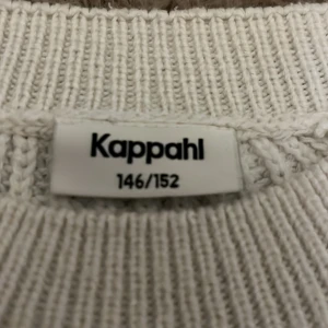 Vit och svart randig stickad tröja Kappahl - Säljer en vit stickad tröja från Kappahl med svarta horisontella ränder. Tröjan har en avslappnad passform, rund halsringning och långa ärmar. Perfekt för att skapa en chill och trendig look.