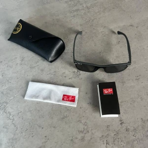 Svarta Ray-Ban  - Snygga svarta Ray-Ban solglasögon modell 4487P med rektangulär form och polariserade mörka glas. Kommer med originalfodral, putsduk och manual. Perfekta för att ge en cool vibe till din stil.
