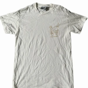 Vit Vintage T-Shirt - Riktigt stilren Vit vintge t-shirt med skönt gult tryck på framsida och baksida. Skönt material och aldrig använd. Lite skrynklig ifrån att ha legat, men går att lösa med strykjärn. Storlek S