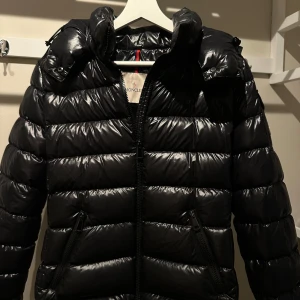 Svart Moncler Jacka Bady - Säljer denna svarta Moncler jacka i dam-modellen Bady i storlek 2, vilket motsvarar M🖤Jag skulle dock säga att den även passar S beroende på hur tight man vill att den ska sitta. Jag köpte jackan på Moncler butiken i Stockholm hösten 2020. Jag har tyvärr inte kvar kvittot, men kontoutdrag finns såklart. Även äkthetsverifiering finns där jag har skrivit in den unika koden som finns i jackan och verifierat på Monclers hemsida, se bild 5. Jackan är i fint skick! ✨