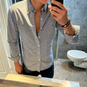 Rutig skjorta från Ralph Lauren - Snygg blåvit rutig skjorta från Ralph Lauren med klassisk button-down krage och broderad logga på bröstet. Skjortan har lång ärm, smal passform och är tillverkad i mjuk bomull. Perfekt för dig som gillar stilren och tidlös look. Jag är 188cm och på mig passar den bra kanske lite kort. Skjortan är i riktigt bra skick! Hör av er vid frågor;) 