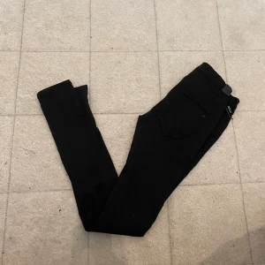 Svarta Replay Hyperflex jeans - Svarta Replay Hyperflex jeans med smal passform och klassisk femficksdesign. Stretchigt material som ger extra komfort och rörelsefrihet. Perfekta för dig som gillar en stilren look med mycket flexibilitet.