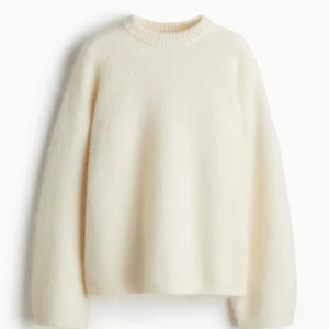 Vit stickad tröja från HM - Supermjuk och fluffig vit stickad tröja från HM med rund hals och breda ribbade muddar. Oversized passform och långa ärmar, perfekt för lager-på-lager. Gjord i en ullmix som känns lyxig och varm. Enkel och stilren design som funkar till allt.