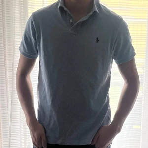 Ljusblå Polo Ralph Lauren pikétröja - Säljer en klassisk ljusblå pikétröja från Polo Ralph Lauren. Den är i storleken M och är i ett riktigt fint skick🤩🤩