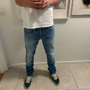 Replay Anbass ljusblå jeans herr - Säljer ett par Replay Anbass jeans i ljusblå tvätt med snygga slitningar. Jeansen har smal passform och normal midja, tillverkade i stretchig bomullsdenim för komfort.  W28 L 32