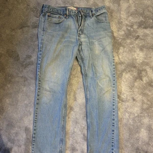 Levi's 505 ljusblå straight jeans 32/32 - Klassiska ljusblå Levi's 505 jeans med straight fit. Femficksmodell med dragkedjegylf och snygga kontrastsömmar. Perfekta för dig som gillar en tidlös och avslappnad look. Ikonisk läderpatch bak i midjan och slitstarkt jeanstyg.
