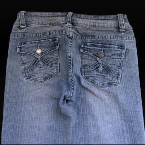 Blå bootcut jeans med fickdetaljer - Så snygga vintage bootcut jeans med coola fickor från Jane Norman . Midjemåttet är 34 och ytterbens längden 97. De har några små defekter vilket syns på de sista bilderna men verkligen inget man tänker på. Kom privat vid fler bilder eller frågor.💕