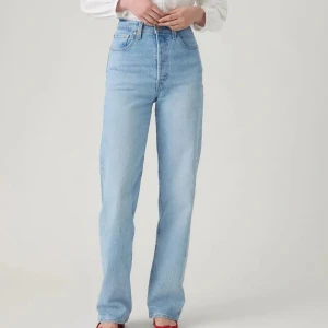 Levi's Ribcage Straight ljusblå jeans - Ljusblå Levi's Ribcage Straight jeans med hög midja och raka ben. Lång benlängd. (24/34). Använda en gång. Nypris ca 1200kr. Klassisk femficksmodell i jeansmaterial med snygg vintagekänsla. Perfekta för dig som gillar en clean och tidlös look. 