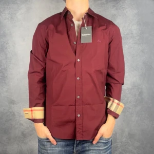 Burberry Skjorta - Skick: 9,5/10, sparsamt använd, inga defekter.  Vad ingår: Endast skjortan.  Ordinarie pris: +-4000 SEK / 400 €.  Modellen är 176 centimeter lång och väger ~70 kilogram.